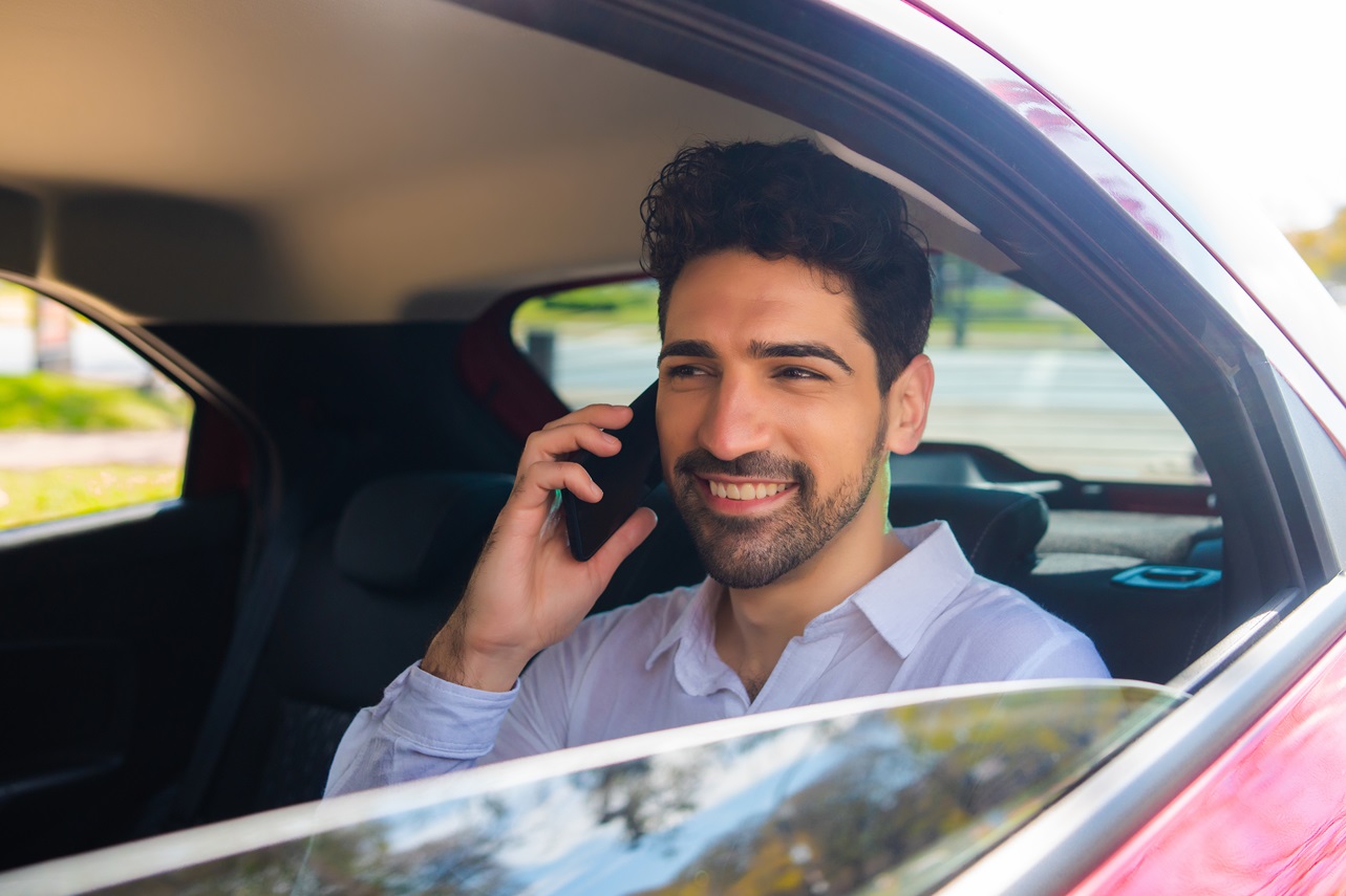 Portrait of businessman talking on phone on way to work in a car. Business concept.